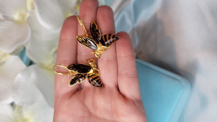 Special product! Wonderful Bees Baltic Amber 14K Gold over .925 Sterling Silver entirely handcrafted earrings - Close-up of bee-shaped earrings in gold and amber, held in hand.