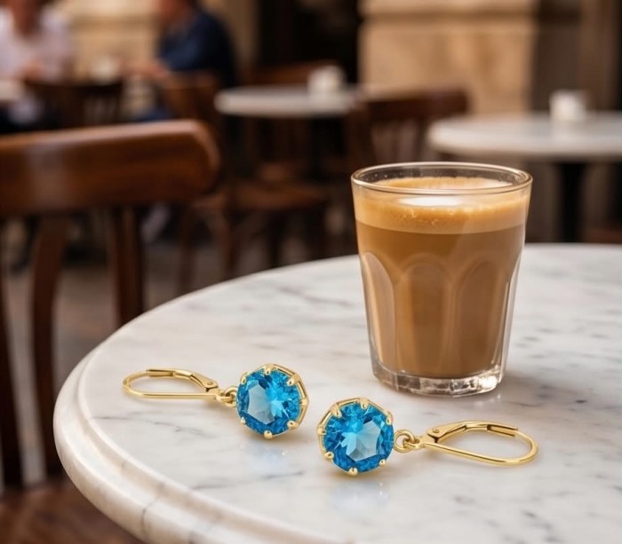 Atlantica 6.8 carat Swiss Blue Topaz 22K Gold over .925 Sterling Silver Handcrafted Statement earrings - Swiss Blue Topaz earrings and coffee on marble table, top view.