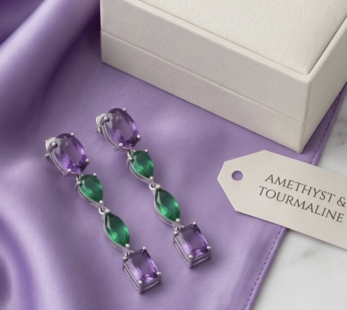 A Heritage in Bloom - Italy made 8.5 carat Amethyst Chrome Diopside .925 Sterling Silver handcrafted earrings - Amethyst and tourmaline earrings on purple silk, top-down view.