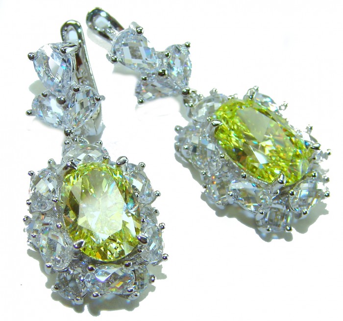 Luxurious 10.5 carat Golden - yellow Montana Sapphire .925 Sterling Silver handcrafted earrings - Close-up of luxurious sapphire earrings with yellow stones and silver setting.