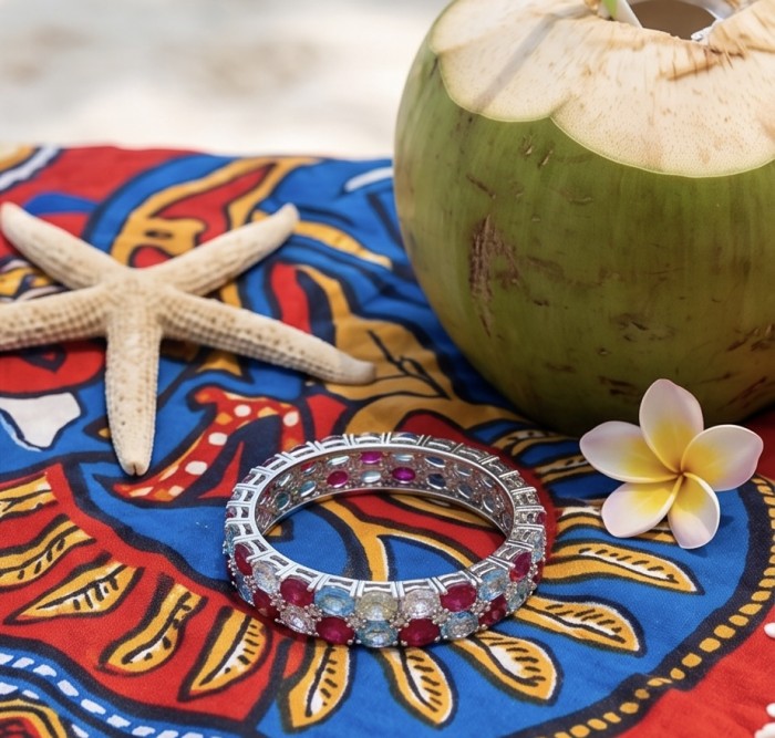 Fiesta Authentic 51.2 carat Morganite Ruby Swiss Blue Topaz .925 Sterling Silver handmade bangle Bracelet - Bracelet on colorful fabric with starfish, coconut, and flower.