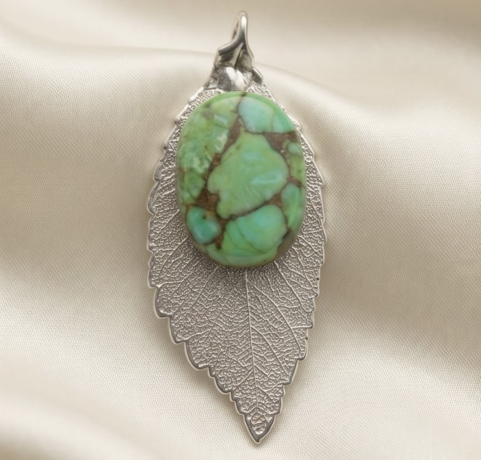Stylish REAL Leaf dipped in .925 Sterling Silver Turquoise Pendant - Leaf-shaped pendant with turquoise stone on soft fabric backdrop.