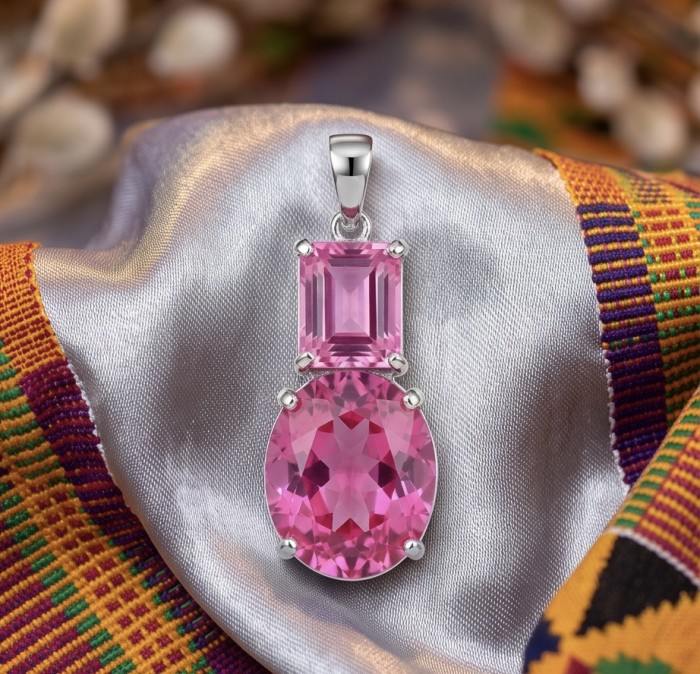 Incredible pear cut 14.8 carat Bubblegum Pink Sapphire .925 Sterling Silver handcrafted pendant - Close-up of pink sapphire pendant on silk and colorful fabric background