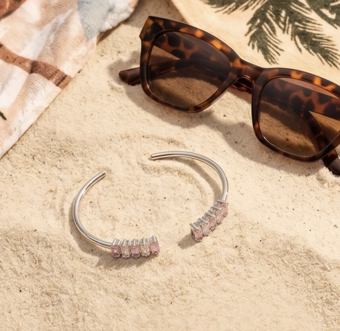Precious Light Natural 6.8 carat Pink Topaz .925 Sterling Silver bracelet - Side view of pink topaz sterling silver open bangles on sand.