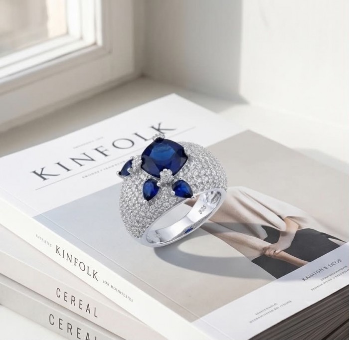 Blue Extravaganza 12.2 carat natural Sapphire .925 Sterling Silver Perfectly handcrafted Ring s. 7 - Blue sapphire ring on stacked books, top view, featuring main stone.