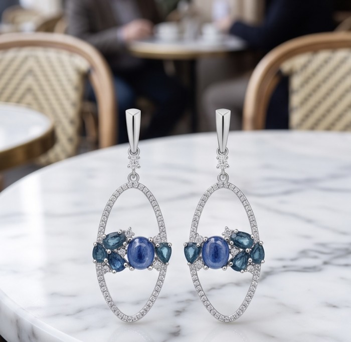 Giovanna - Authentic 8.9 carat Tanzanite .925 Sterling Silver handcrafted earrings - Front view of Giovanna earrings with blue stones on marble table
