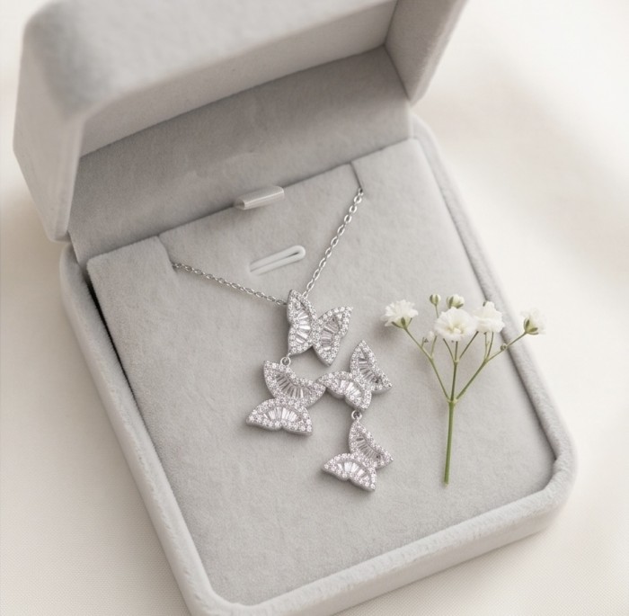 Four Butterflies natural 7.5 carat White Topaz .925 Sterling Silver handmade Statement necklace - Butterfly necklace in open box with flowers, top view.
