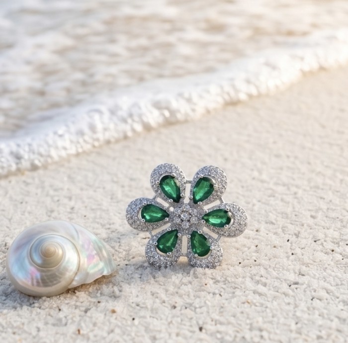 Giovanna - Authentic 10.9 carat Colombian Emerlad .925 Sterling Silver Silver dipped in Rhodium handcrafted Ring size 8 - Emerald flower ring close-up on beach with shell background.