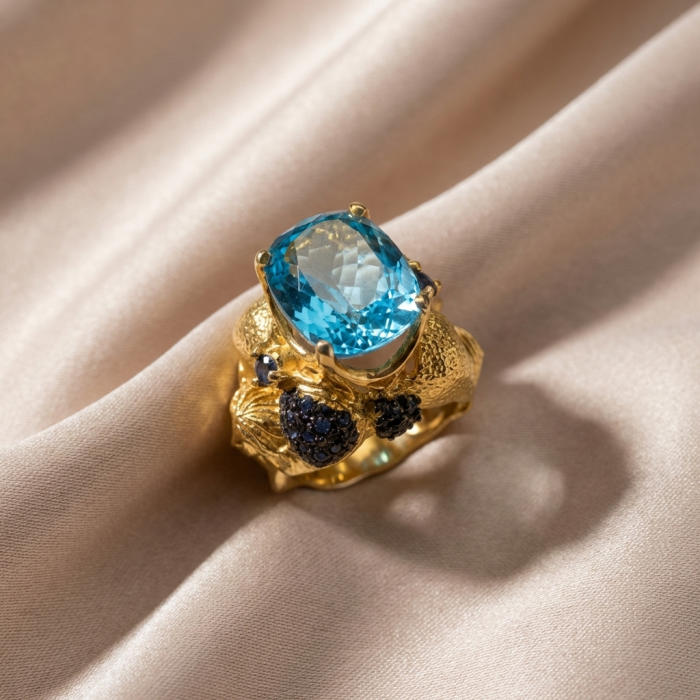Poseidon 24.8 carat Swiss Blue Topaz 0.7 carat Black Diamond .925 Sterling Silver dipped in 22K Gold handcrafted Large ring size 7 - Gold ring with blue topaz and black diamonds on fabric background
