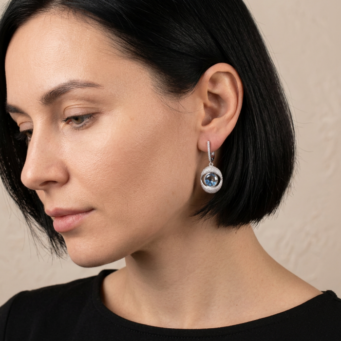Floating Memories 11.5 carat Sapphire .925 Sterling Silver Handcrafted Statement earrings - Side view of woman wearing sapphire drop earring in silver setting.