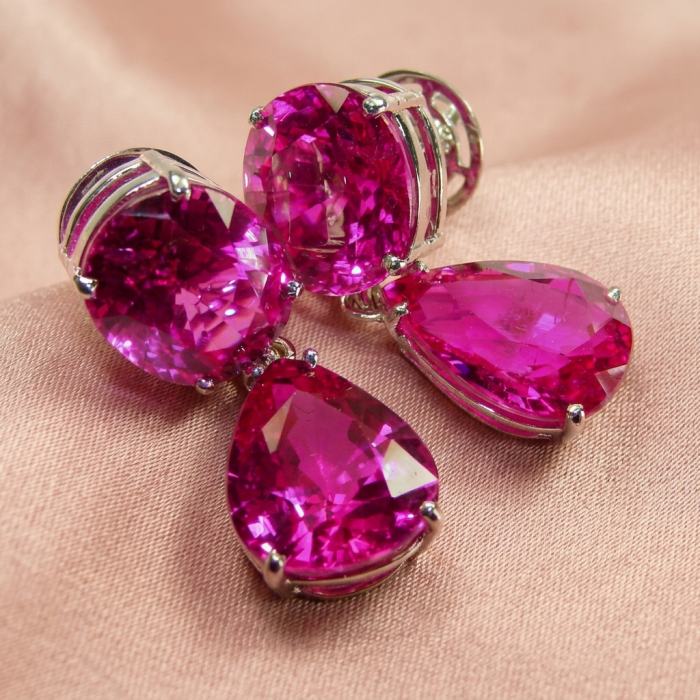 Tiffany - authentic 44.8 carat Pink Sapphire .925 Sterling Silver handcrafted Statement Earrings - Pink Sapphire earrings close-up on pink fabric background