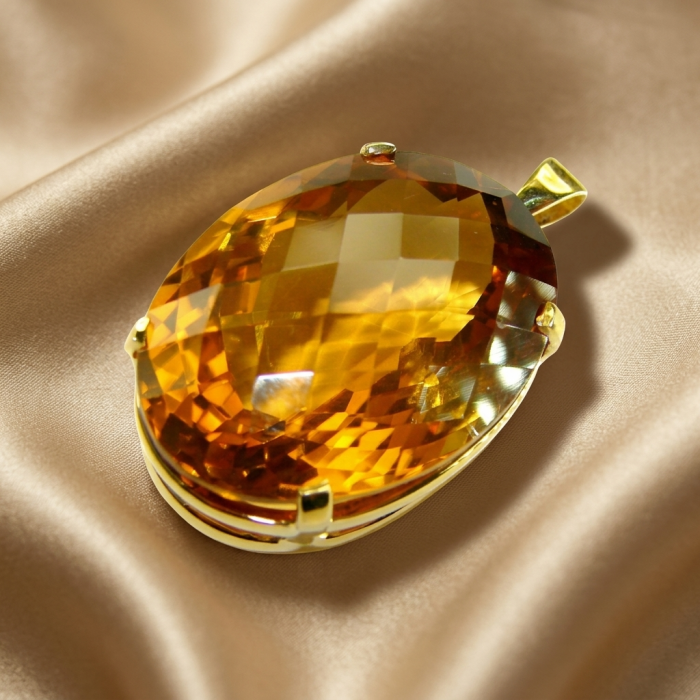 Luxury genuine 39.7 CARAT oval cut Champagne Topaz .925 Sterling Silver dipped in 22K Gold handmade Pendant - Close-up of luxury 39.7 carat oval cut Champagne Topaz pendant on fabric