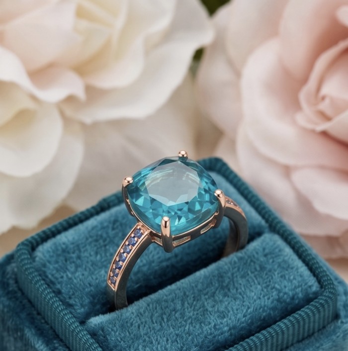 Costa del Sol 7.8 carat Apatite 14K Rose Gold .925 Sterling Silver Handcrafted Statement Ring size 7 - Side view of apatite ring in box with rose and blue accents