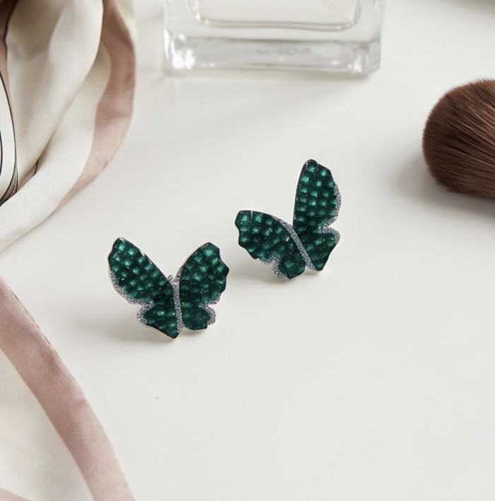 Incredible Butterflies genuine 15.5 CARAT Emerald .925 Sterling Silver handcrafted Earrings - Emerald butterfly earrings on table, front view.