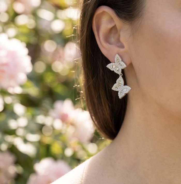 Four Butterflies natural 7.5 carat White Topaz .925 Sterling Silver handmade Statement Earrings - Side view of Four Butterflies earrings worn on ear, floral background