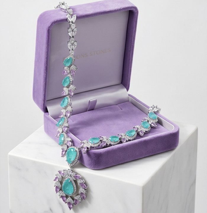 Wonderland 95.8 carat Paraiba Tourmaline rhodium over .925 Sterling Silver Handcrafted Statement necklace - Necklace in lavender box, front view, featuring Paraiba Tourmaline stones.