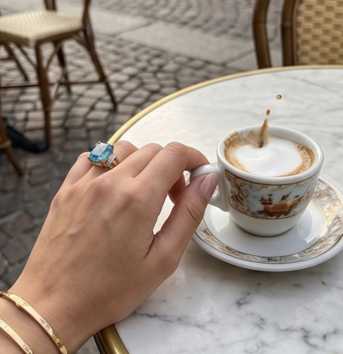 Paradise Natural 27.8 carat Swiss Blue Topaz .925 Sterling Silver dipped in 22K Gold handmade Large Statement Ring size 7 3/4 - Worn on hand, blue topaz ring next to a coffee cup on a marble table.