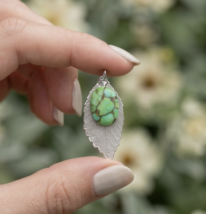 Stylish REAL Leaf dipped in .925 Sterling Silver Turquoise Pendant - Close-up of silver leaf pendant with turquoise, held between fingers.