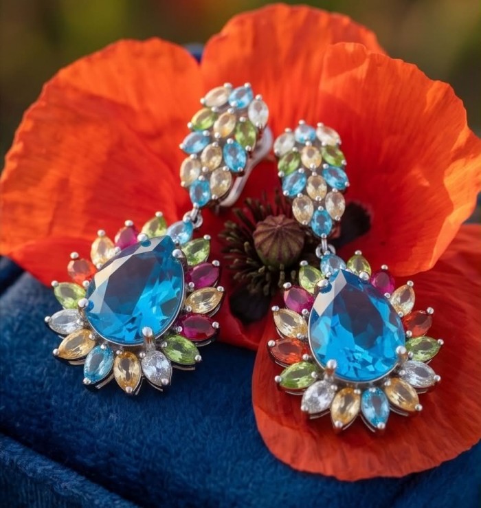Atlantica 33.7 carat Swiss Blue Topaz .925 Sterling Silver dipped in rhodium Handcrafted Statement earrings - Close-up of Atlantica Swiss Blue Topaz earrings on red flower.