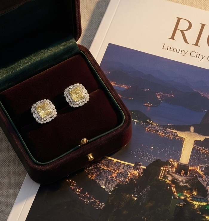 4.5 carat Golden - yellow Montana Sapphire .925 Sterling Silver handcrafted earrings - Golden-yellow sapphire earrings in box, top view on cityscape background.