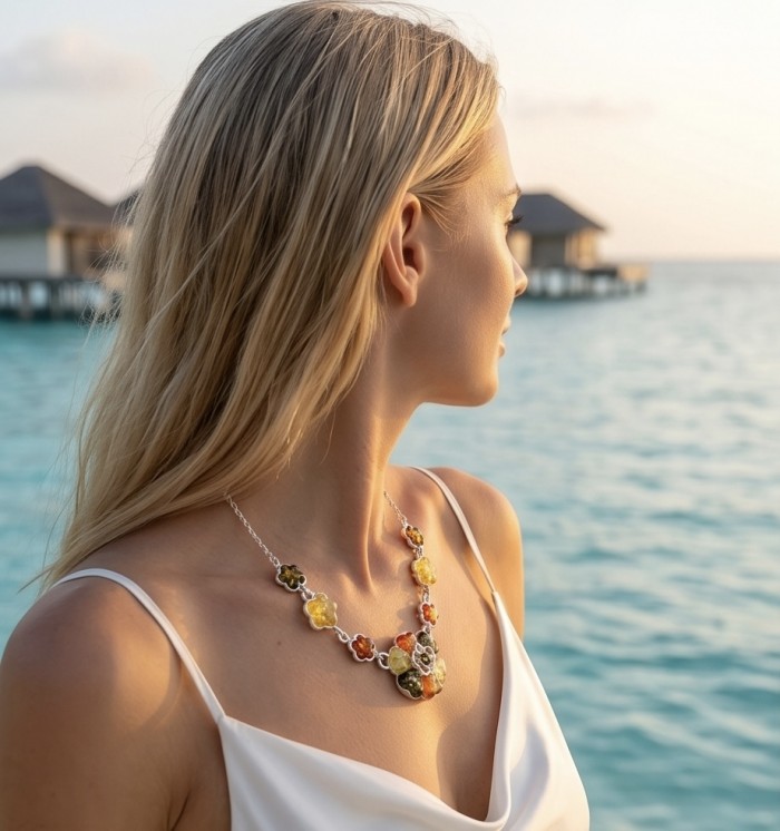 Floral design - natural multicolor Baltic Amber .925 Sterling Silver handcrafted necklace - Side view of floral Baltic Amber necklace worn by a woman at the beach.