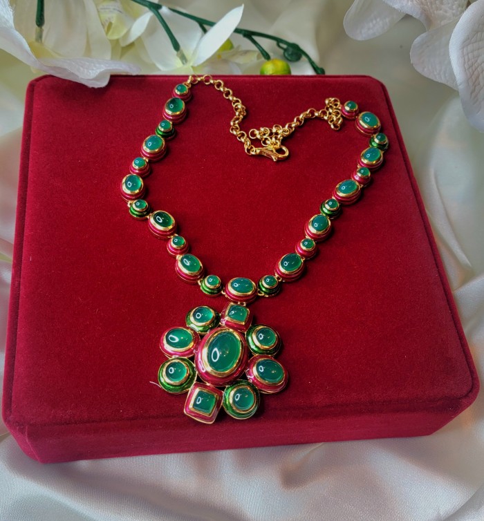 Authentic 155.8 carat Jade red Enamel .925 Sterling Silver dipped in real 18K Gold over handcrafted necklace - Red velvet display of jade necklace with green stones, top view.