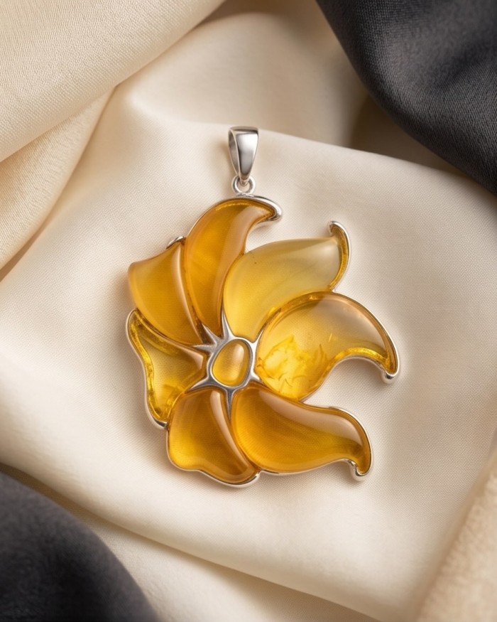 Golden Wild Lotus Natural Butterscotch Baltic Polish Amber .925 Sterling Silver dipped in rhodium handcrafted Pendant - Golden lotus amber pendant on fabric, top view.